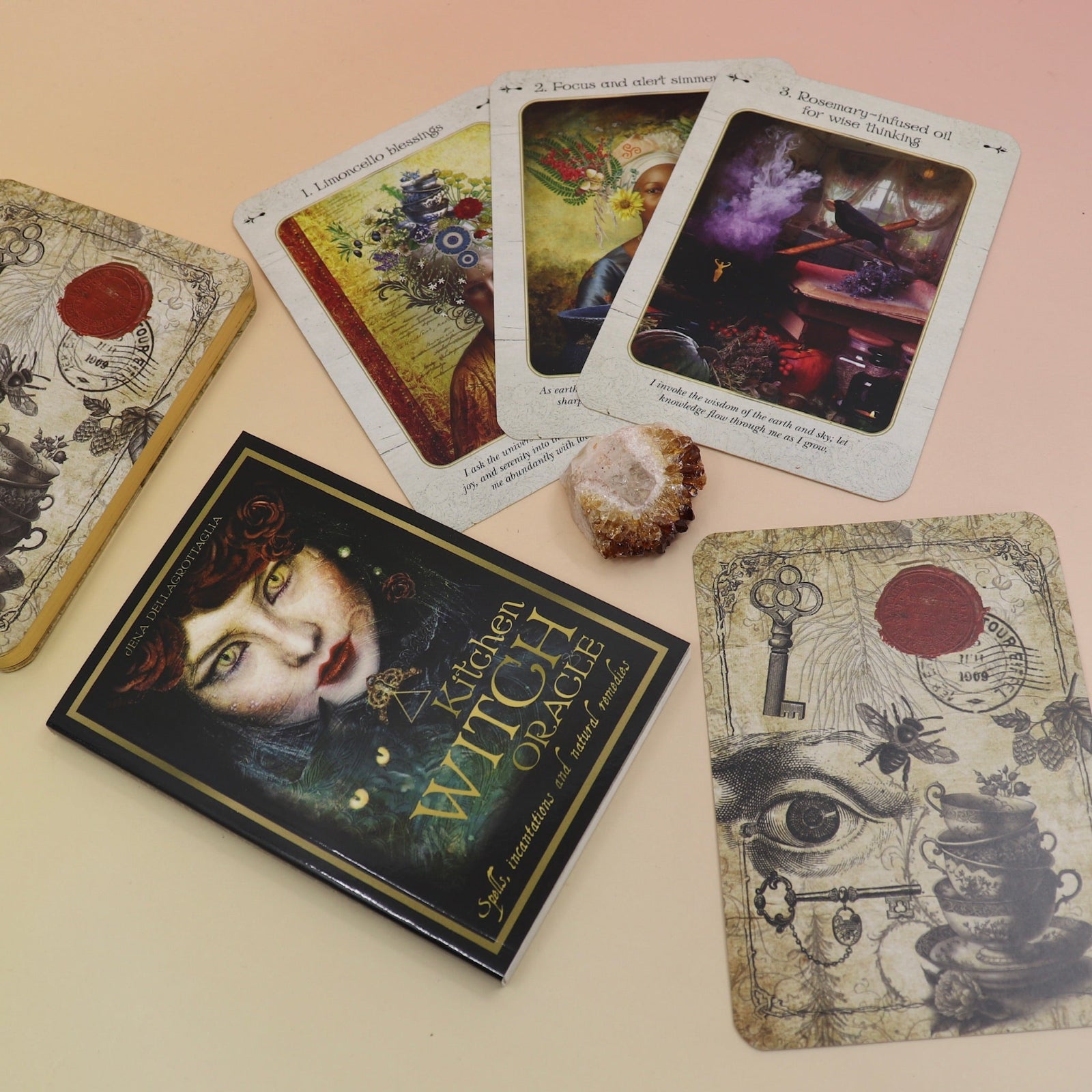 The contents of the Kitchen Witch Oracle Deck on a pink and yellow background.