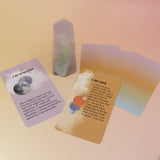 The contents of the Affirmation Card Deck and a crystal tower on a pink and yellow background.