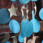 An up-close image of the chapiz and coconut accents within the Moon & Stars Capiz Chime.
