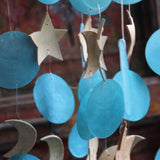 An up-close image of the chapiz and coconut accents within the Moon & Stars Capiz Chime.
