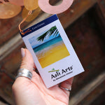 An image of someone holding the tag of the Sunlit Bay Capiz Chime in front of a door.