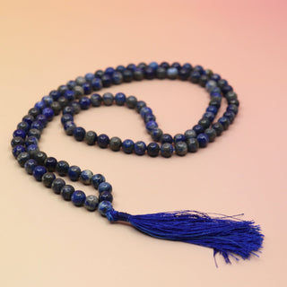 Lapis Lazuli 108 Mala Necklace on pink and orange background