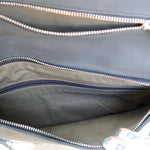 Close-up of a black leather clutch bag with zippers