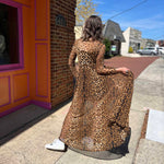 leopard mesh dress on model standing in front of orange and pink building view from the back