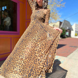 leopard mesh dress on model standing in front of orange and pink building holding skirt out to the left