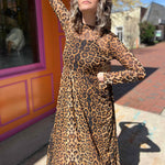 leopard mesh dress on model standing in front of orange and pink building with models hand on hip