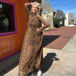 leopard mesh dress on model standing in front of orange and pink building wiht models hand in hair and one on hip
