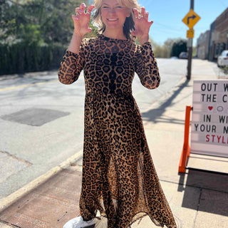 leopard mesh dress on model standing in front of orange and pink building with hands in claw formations growling
