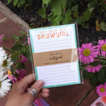 Hand holding a notepad with floral background