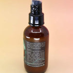 back of the litha essential oil spray with list of ingredients on an orange and pink background