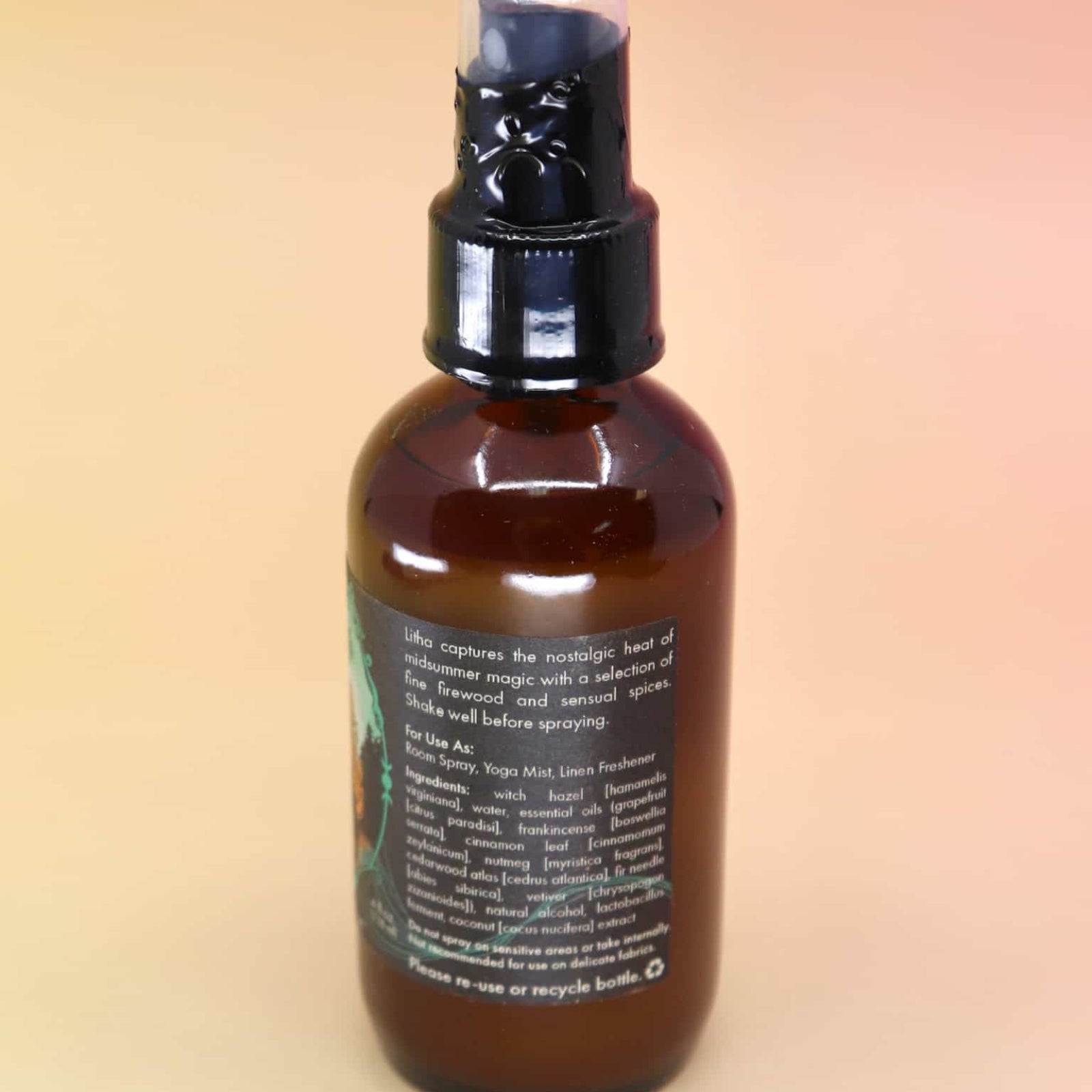 back of the litha essential oil spray with list of ingredients on an orange and pink background