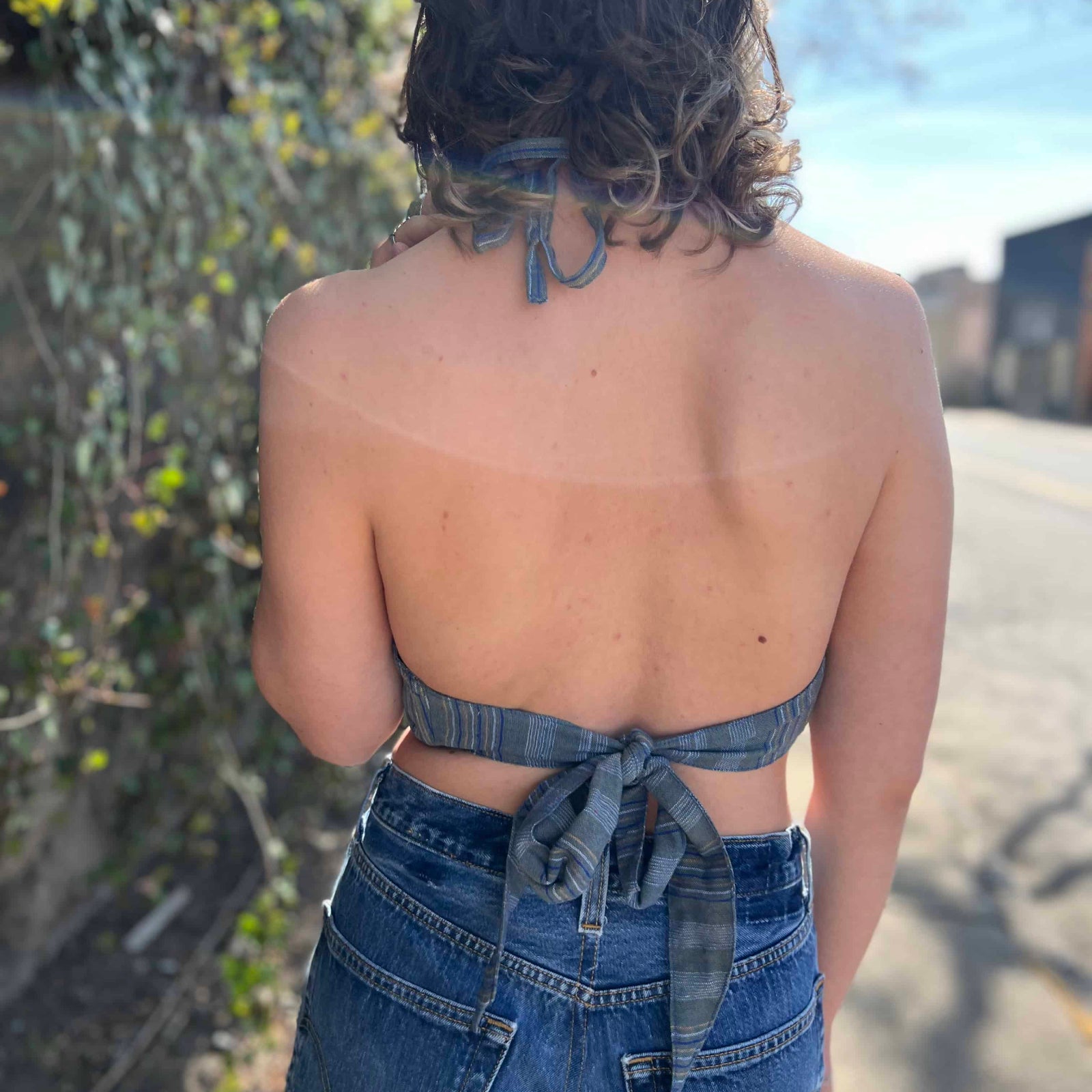 view from back Model wearing blue floral halter top with back tie - Midnight Floral Top