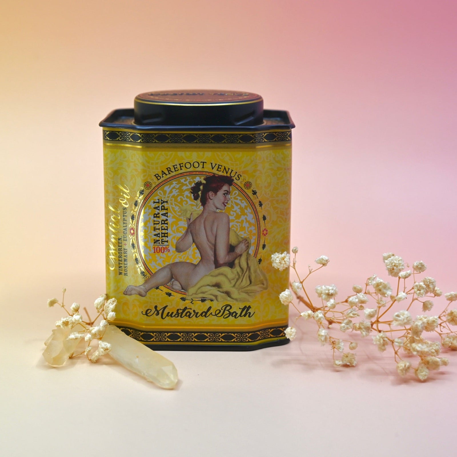 The 100% Natural Mustard Bath Soak with a crystal and dried flowers in front of it on a light pink background.
