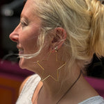 Boho style model smiling with large star earrings