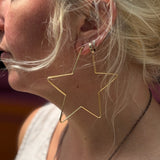 Close-up of 18K gold star hoop earring on ear