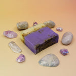 Purple soap bar with natural stones on a beige background