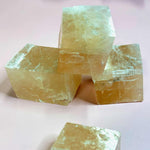 Raw calcite cubes stacked and glowing under soft lighting close up