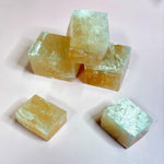 Raw calcite cubes stacked and glowing under soft lighting