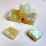 Raw calcite cubes stacked and glowing under soft lighting