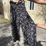 Someone holding the black Celestial Faux Wrap Pants.