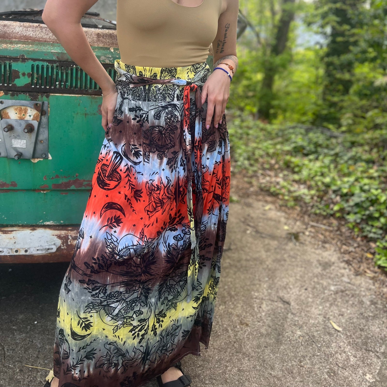 Someone wearing the Mushroom Tie-Dye Maxi Skirt in front of an old teal Volkswagen bus.