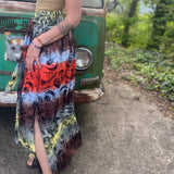 Someone wearing the Mushroom Tie-Dye Maxi Skirt in front of an old teal Volkswagen bus.