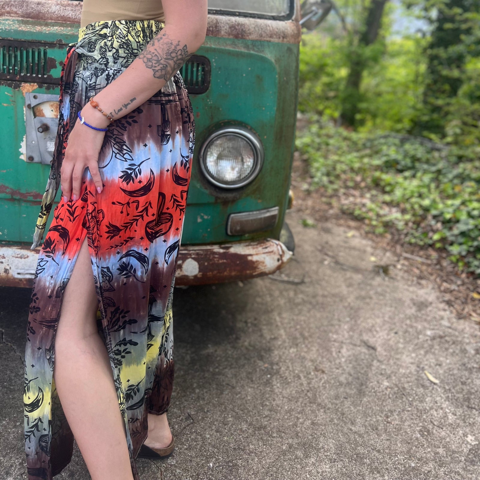 Someone wearing the Mushroom Tie-Dye Maxi Skirt in front of an old teal Volkswagen bus.