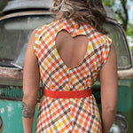 girl in 1970s Gingham Belted Romper in front of green VW vintage bus