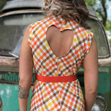 girl in 1970s Gingham Belted Romper in front of green VW vintage bus