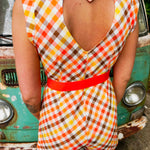 girl in 1970s Gingham Belted Romper in front of green VW vintage bus