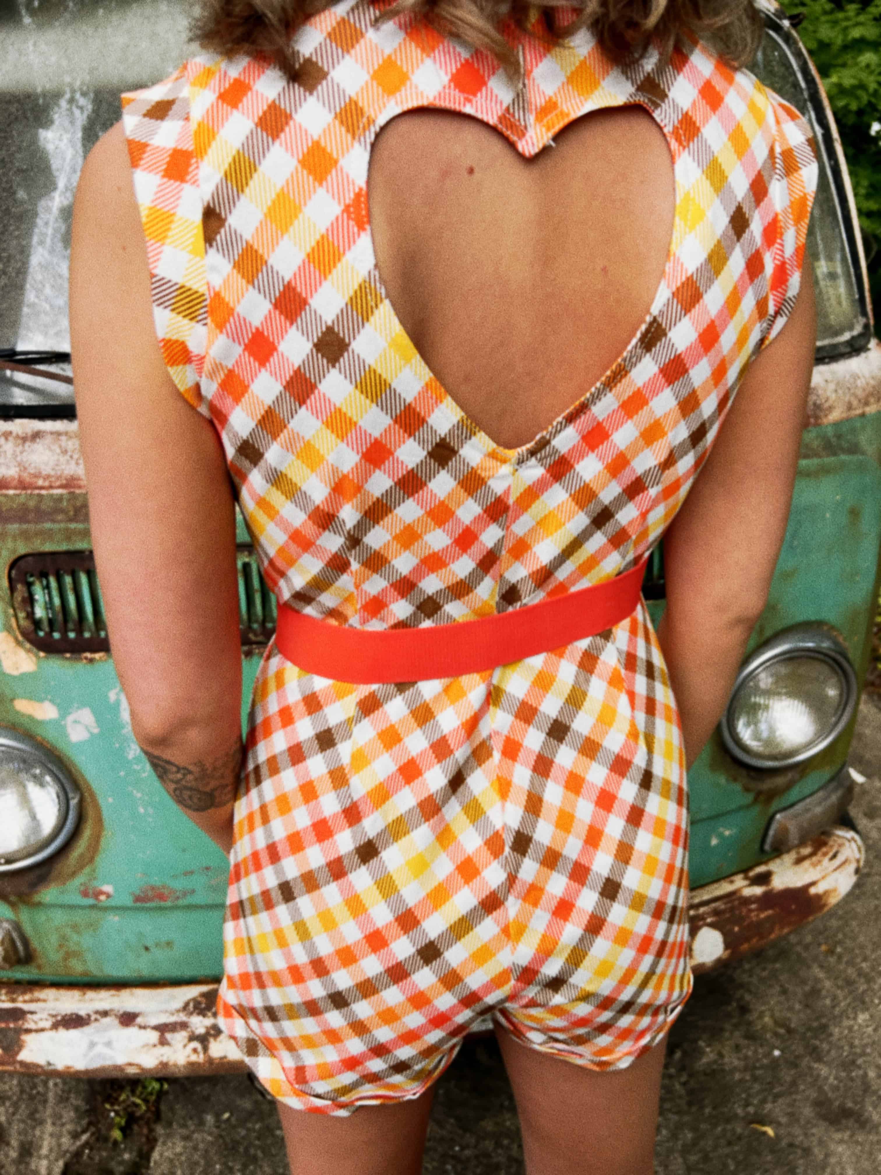 girl in 1970s Gingham Belted Romper in front of green VW vintage bus