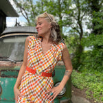 girl in 1970s Gingham Belted Romper in front of green VW vintage bus