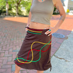 Someone wearing the Sinker Skirt with Rasta Piping.