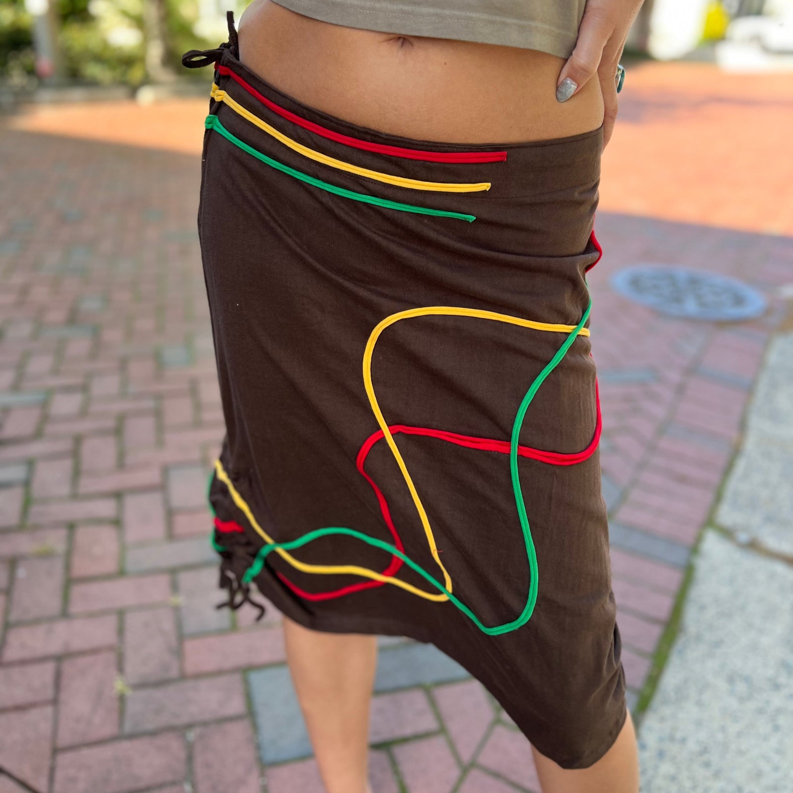 Someone wearing the Sinker Skirt with Rasta Piping.