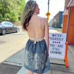 Someone wearing the Midnight Floral Crochet Halter Dress.