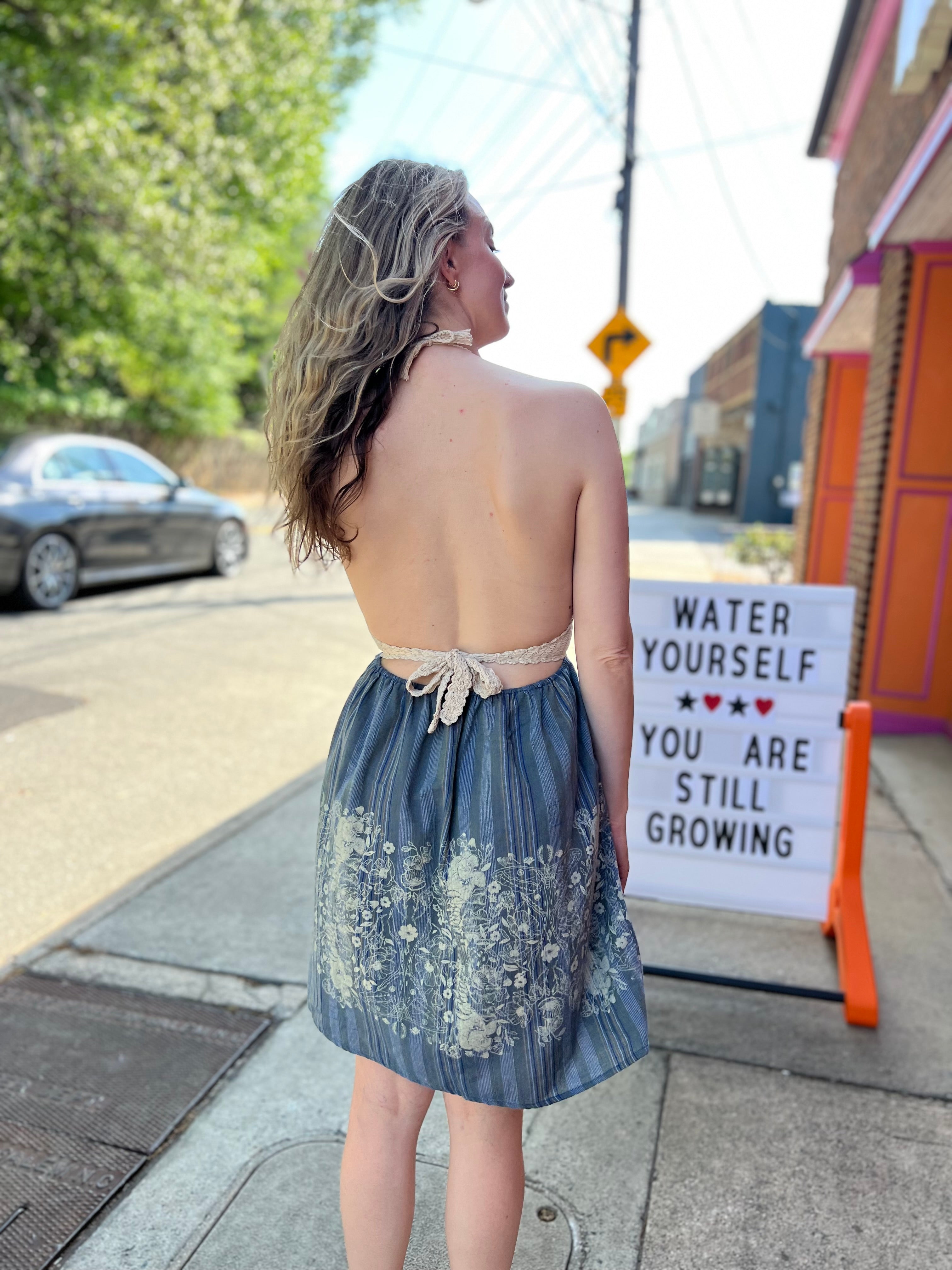 Someone wearing the Midnight Floral Crochet Halter Dress.