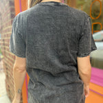 A woman wearing the Gray Mandala Stonewashed Cotton T-shirt with jeans in front an orange and pink wall.