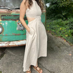 A woman wearing the cream Solid Linen Cut-Out Midi Dress in front of a vintage teal Volkswagen bus.