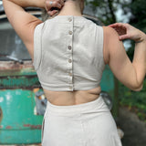 A woman wearing the cream Solid Linen Cut-Out Midi Dress in front of a vintage teal Volkswagen bus.