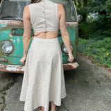 A woman wearing the cream Solid Linen Cut-Out Midi Dress in front of a vintage teal Volkswagen bus.