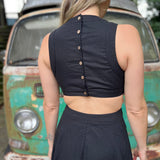 A woman wearing the black Solid Linen Cut-Out Midi Dress in front of a vintage teal Volkswagen bus.