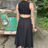 A woman wearing the black Solid Linen Cut-Out Midi Dress in front of a vintage teal Volkswagen bus.