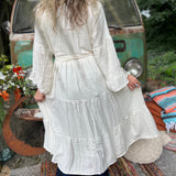A woman wearing the white Organic Tiered Maxi Kimono Wrap Dress in front of a vintage Volkswagen bus.