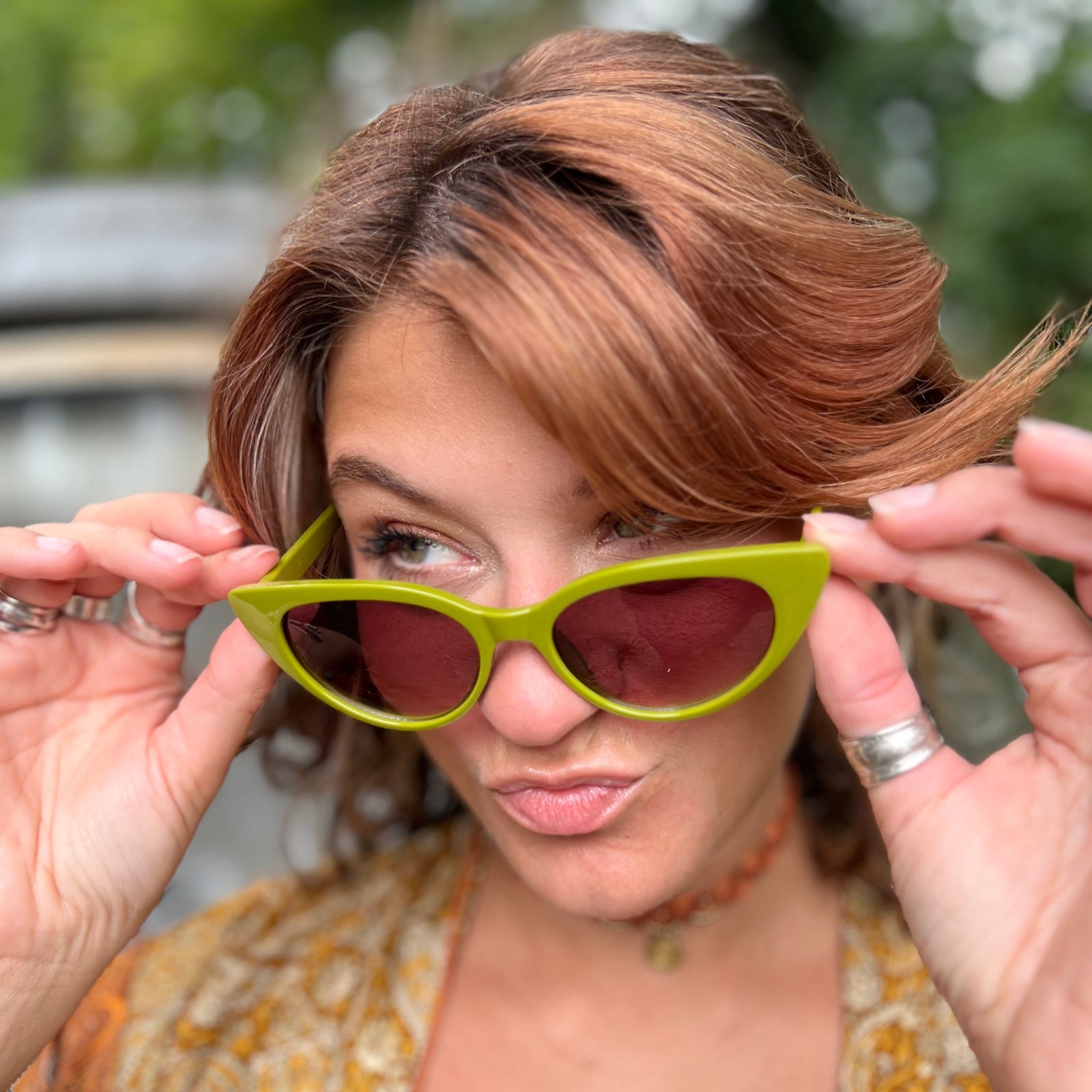 Someone wearing the Frenchie Seventies Cat-Eye Sunglasses with an orange patterned kimono.