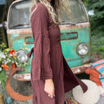 A woman wearing the marron brown Organic Tiered Maxi Kimono Wrap Dress in front of a vintage Volkswagen bus.