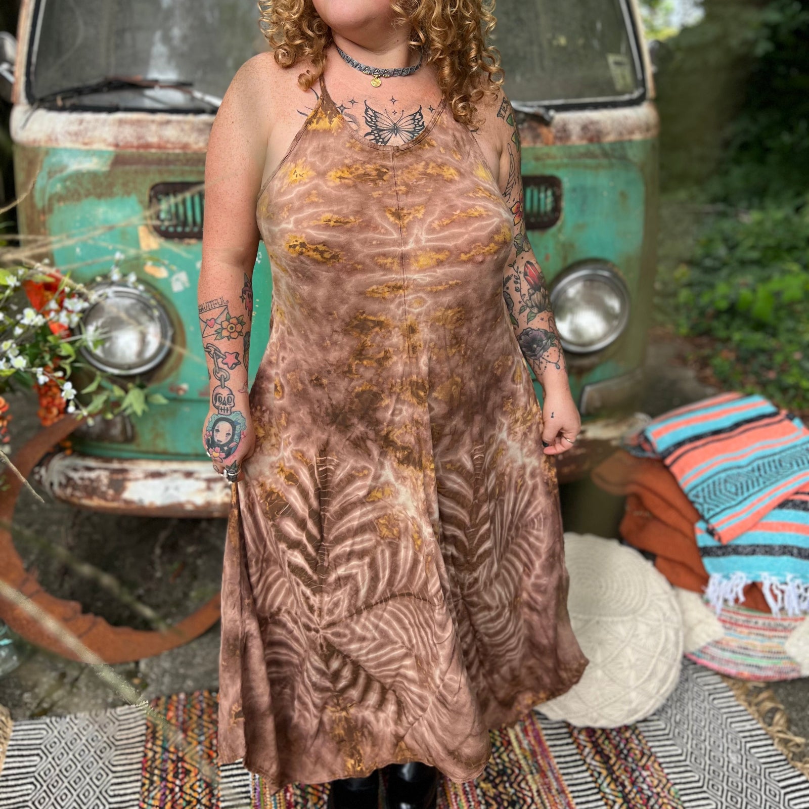 A woman wearing the moondance mauve gold Hippie Boho Maxi Flowy Tie Dye Dress in front of a vintage Volkswagen Bus.