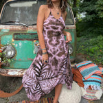 A woman wearing the moondance mauve gold Hippie Boho Maxi Flowy Tie Dye Dress in front of a vintage Volkswagen Bus.