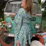 A woman wearing the green Hippie Bohemian Fairy Dress with Elastic Fairy Skirt in front of a vintage Volkswagen bus.