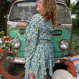 A woman wearing the green Hippie Bohemian Fairy Dress with Elastic Fairy Skirt in front of a vintage Volkswagen bus.