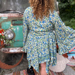 A woman wearing the green Hippie Bohemian Fairy Dress with Elastic Fairy Skirt in front of a vintage Volkswagen bus.